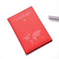 Detail of red PU leather passport cover showing world map and aircraft embossing - Red