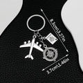 Silver airplane keychain with passport and compass charms on black leather background - Plane Passport Compass (ER678)