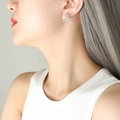 Orecchini minimalisti in argento 925 a ventaglio radiale indossati da modella - Color Acciaio