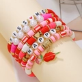 Detail of red and pink Heishi beaded bracelets with KISS ME and HAPPY lettering - Red Pink KISS ME/HAPPY Set