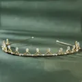Detailed shot of golden leaf headband with cat-eye stones and pearls on green fabric - Cat Eye Proud Queen Crown