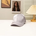 Detalle de la gorra de béisbol de satén plateado con tela brillante y borde pespunteado - Gris
