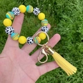 Close-up of yellow silicone beaded bracelet with cow print bead and stylish yellow tassel - Yellow Cow Rainbow Style