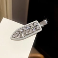 Nahaufnahme einer silbernen Haarklammer in Dolchform mit funkelnden weißen Zirkonia-Steinen - Kreativer Messer-Stil / Silber
