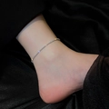 Sparkling silver twisted titanium steel anklet on female ankle against black silk - Anklet / Steel
