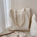 Dettaglio della borsa tote in pizzo ricamato beige con etichetta e accessori coordinati - Stile con doppia tracolla