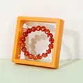 Red agate bead bracelet in a yellow 3D floating film jewelry display case - Orange