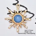 Detailed view of a 2.7x3.0cm golden sunburst alloy charm with a blue translucent bead - Jelly Blue