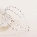 Elegante diadema plateada de doble capa con perlas blancas sobre un fondo beige suave - Plateado