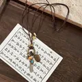 Detalle de un collar bohemio con borlas, cuentas de madera y amuletos vintage - Estilo Pequeña Pluma Plateada 2#