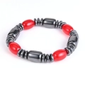 Close-up of elastic yoga bracelet with red oval beads and metallic dark grey magnetic stones - Red Barrel Bead Bracelet