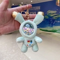 Close-up of light green astronaut bunny plush keychain with colorful beads in a sphere - Space Rabbit Green
