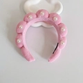 Pink braided sponge headband with pearl accents on a white decorative stand - Pink With Pearls