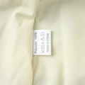 Macro view of a 100% polyester care label with washing instructions on a chiffon dress - S / Off White