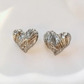 Primer plano de pendientes de corazón plateados con textura de lava y acabado pulido - Pendientes / Plateado