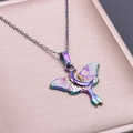 Detailed shot of iridescent moon and moth pendant necklace on pink jewelry box - Iridescent Pendant Necklace