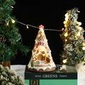 Dettaglio carillon natalizio rotante in resina con luci LED e scena innevata miniatura - Omino di pan di zenzero rosa