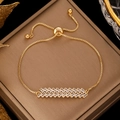 Adjustable gold crystal box chain bracelet featuring rectangle stones on a satin cushion - Gold Staggered Baguette Zirconia Bolo