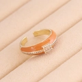 Dettaglio dell'anello dorato in smalto arancione con zirconi su vassoio in velluto - Taglia Unica(Regolabile) / Arancione
