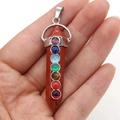Detailed close-up of a hexagonal crystal pendant featuring seven colorful chakra gemstones - 7 Chakra Red Jasper