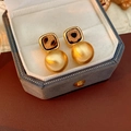 Detail of square leopard print stud earrings with matte gold spheres in a velvet gift box - Gold