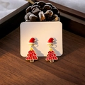 Détail de boucles d'oreilles sapin et bonnet de Noël sur fond de bois et pommes de pin - E5947-7 Bonnet de Noël Sapin