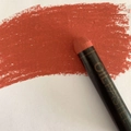 Single reddish brown oil pastel showing thick textured brushstrokes on white art paper - Brown