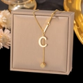 Detail of gold titanium pendant necklace featuring capital letter C and a small cube charm - Letter C-Gold