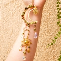 Detail of golden crescent moon suncatcher with raw green crystals and star charms - Unakite