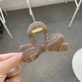 Detail of mocha brown bow hair claw clip featuring a sturdy golden metal spring - Approx. 8cm / Transparent Brown