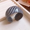 Detail of wide black and white striped resin open bangle on a beige velvet jewelry box - 44# Bangle-Black-White-Vertical Stripe