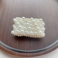 Macro shot of rectangular cream faux pearls on a vintage wooden tray background - White