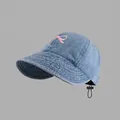 Detail of blue denim baseball cap featuring pink bow embroidery and adjustable drawcord - Drawstring Wide Brim Sun Hat Style / Light Blue