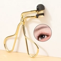 Macro shot of gold stainless steel eyelash curler with black silicone pad for precision curling - Sectional Gold