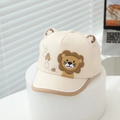 Dettaglio del cappellino per bambini in cotone crema con toppa leone 3D e orecchie - 50-52cm (2-5 Anni) / Beige