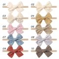 Flat lay collection of ten baby bow headbands in various colors and floral patterns - Multicolor Set