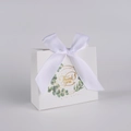 Close-up of white paper gift bag with eucalyptus wreath design and white silk bow detail - Eucalyptus + White Ribbon