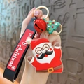 Cute Christmas keychain featuring a Santa Claus figure, green tree, and red bell on a strap - Santa Claus