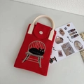 Dettaglio di una mini borsa in maglia rossa con motivo gatto nero e manici rotondi panna - Gatto Rosso su Sgabello
