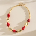 Dettaglio della collana etnica con perle acriliche rosse e dorate irregolari - Rosso