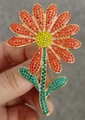 Broche marguerite en émail orange avec cristaux jaunes et finition dorée élégante - Fleur en Strass Orange-Vert