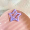 Close-up of purple hollow star-shaped metal hair clip on elegant lace and shell tray - Light Purple