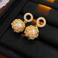 Eleganti orecchini di perle dorate con sfera cava e strass su display in pelle nera - Oro (Perno in argento)