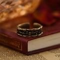 Makroaufnahme des Vintage-Sonnenblumenrings mit Antik-Bronze-Textur auf altem Buch - Oxidierte Textur (JZ-383) / Antikgold
