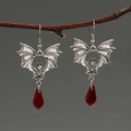 Close-up of gothic black bat earrings with red crystal teardrops on a branch - Antique Silver Bat Style (A-602)