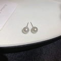 Elegantes pendientes de perlas blancas con agujas de plata en un soporte de exhibición - Estilo Aguja de Plata Gris / 8mm