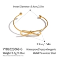 Macro view of gold bow open bangle showing 6.4cm diameter and waterproof steel texture - Gold (YYBL023068-G)