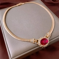Dettaglio collana vintage dorata a serpente con grande gemma ovale rossa e strass - Rosso