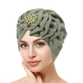 Turbante verde salvia con dettaglio fiore di perle indossato da una modella su sfondo bianco - Verde Menta