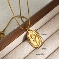 Detail eines goldenen rechteckigen Anhängers mit Tulpenrelief an einer Schlangenkette - Goldene Halskette mit Tulpenprägung in quadratischer Form